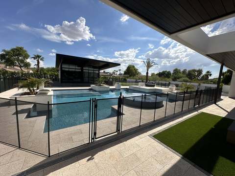 Black mesh pool fence with self-closing gate at a modern home